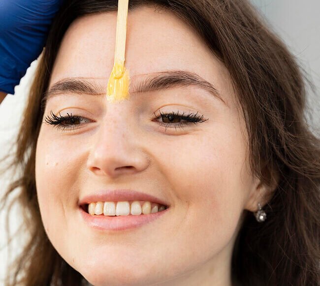 beautician doing eyebrow treatment her female client 1